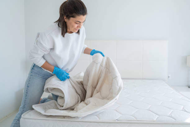 Woman Changing Mattress Topper For Cleaning On Bed